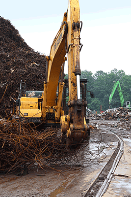 genesis rebar shear on an excavator with rebar piled nearby