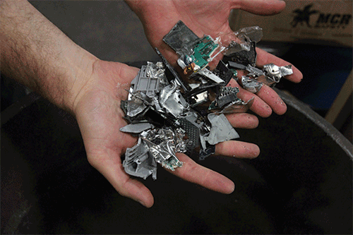 a person holds twisted metal from a shredder in his hands