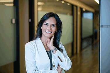 a smiling woman in a white jacket