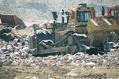 dozer pushing trash in landfill