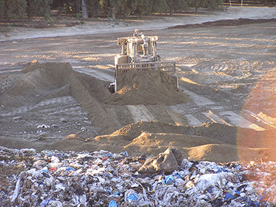 Figure 2 - Dozer placing excessive amount of daily cover soil on rough trash surface.