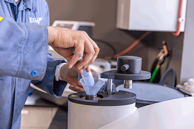 a close up of a person's hand testing a metal sample
