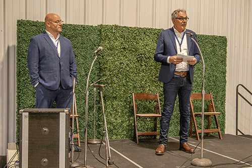 two men stand on a stage
