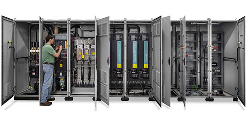 man in front of long electrical cabinet