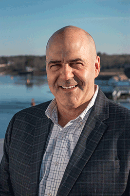 a smiling bald caucasian man in a jacket and button-up
