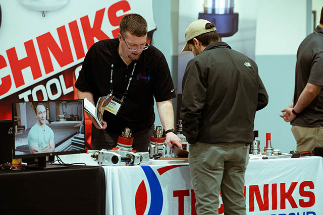 man describing tooling accessories to a visitor